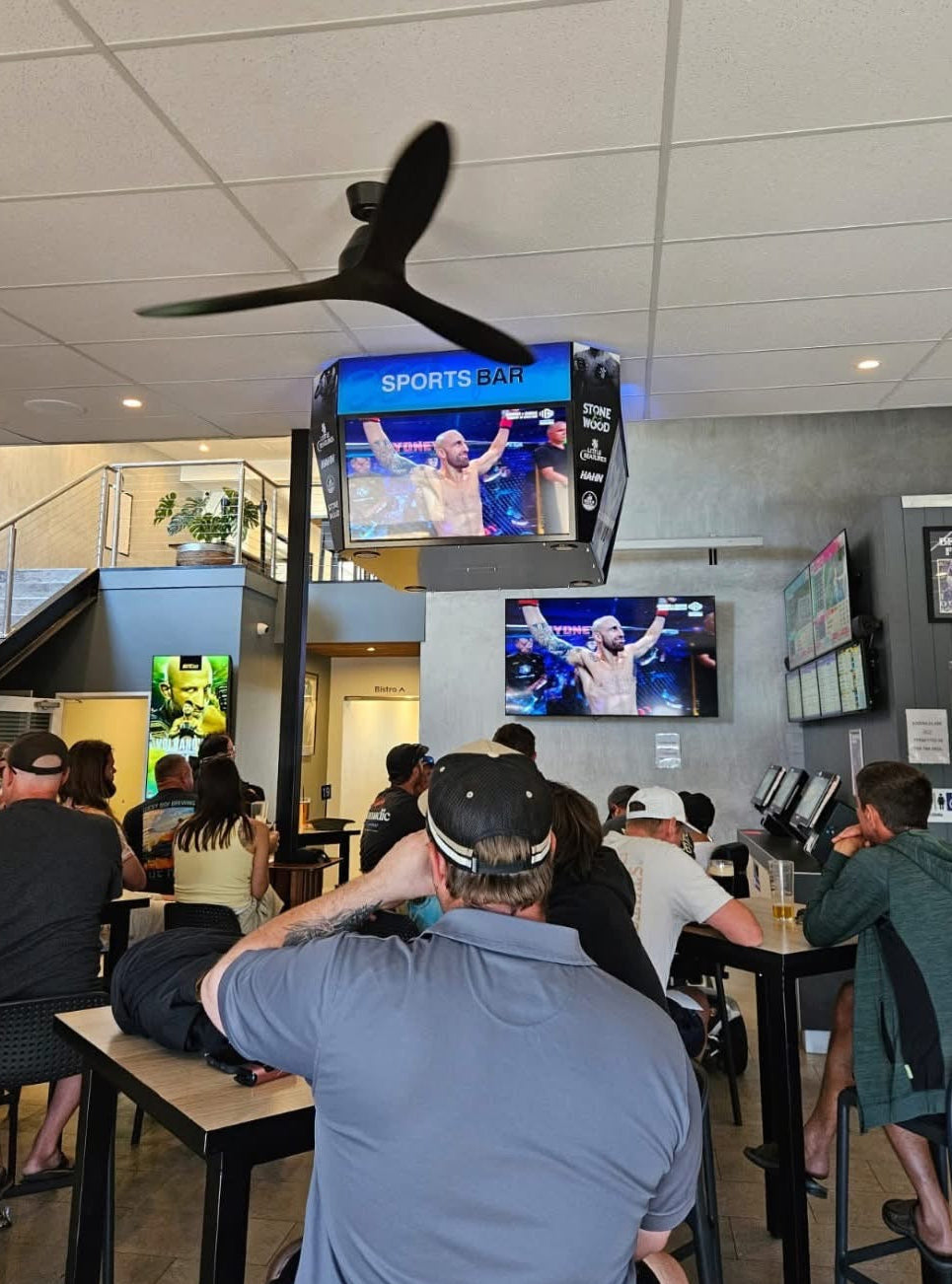 People watching sports on a jumbotron. 